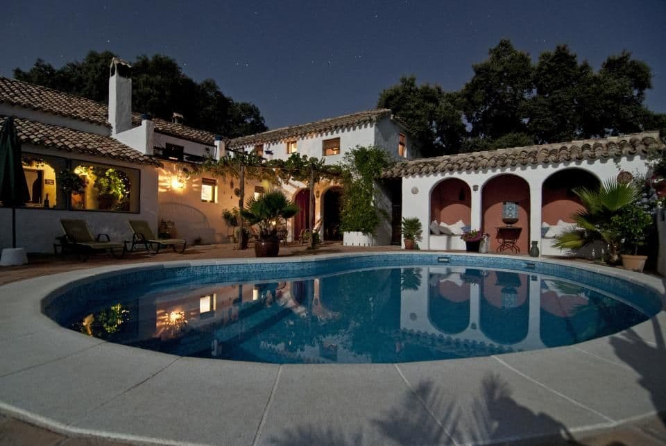 A whitewashed Andalusian villa and its pool at dusk